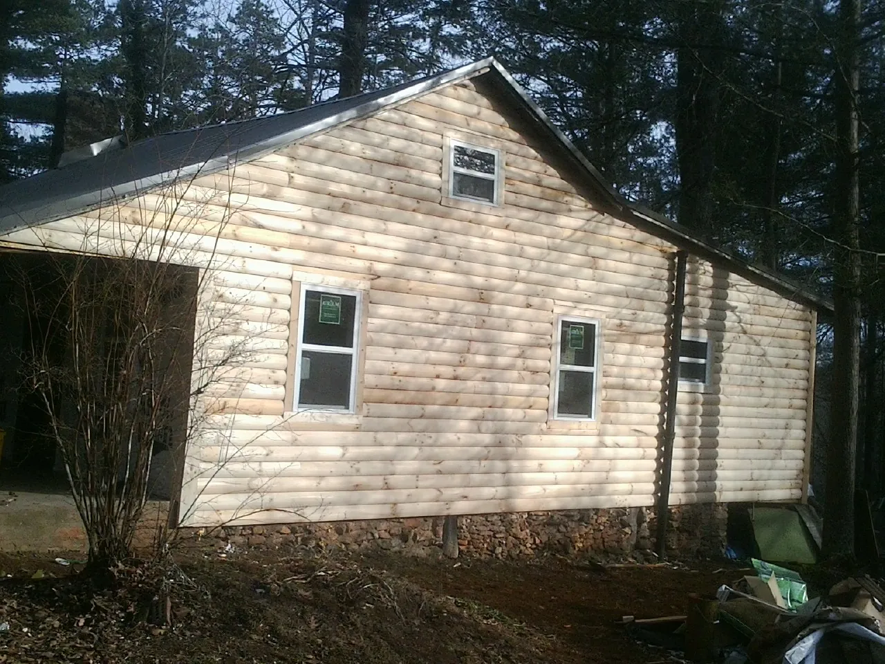 New log siding and dark metal roofing on a gable end in Rhinebeck