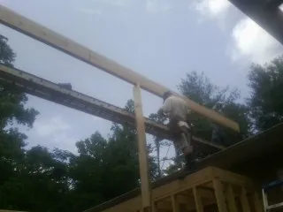 Carpenter setting a ridge beam over a new addition frame — Ice Dam Removal by Roofing Brothers in Rhinebeck