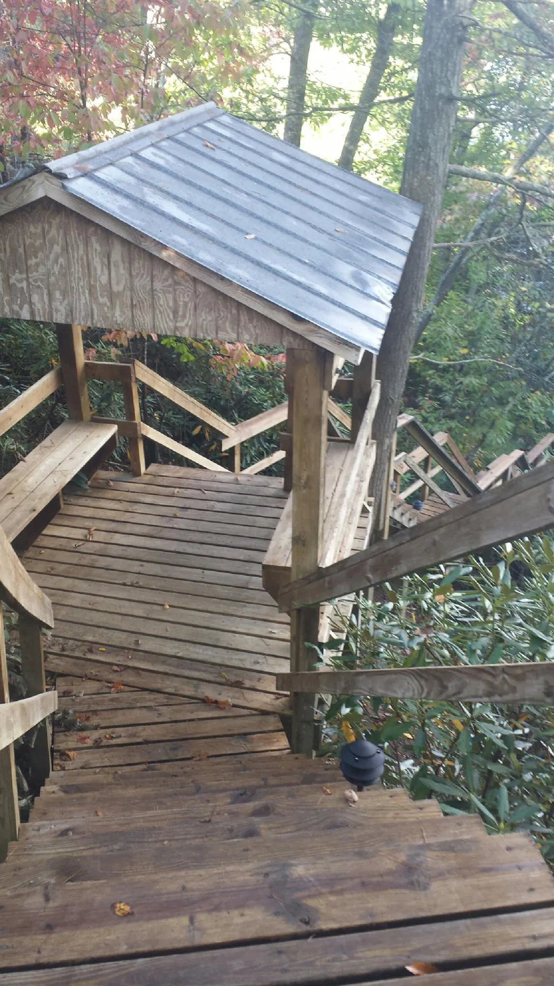 Metal roofed shelter over wooden steps on a wooded walkway — Skylight Repair & Installation work by our crew in Rhinebeck