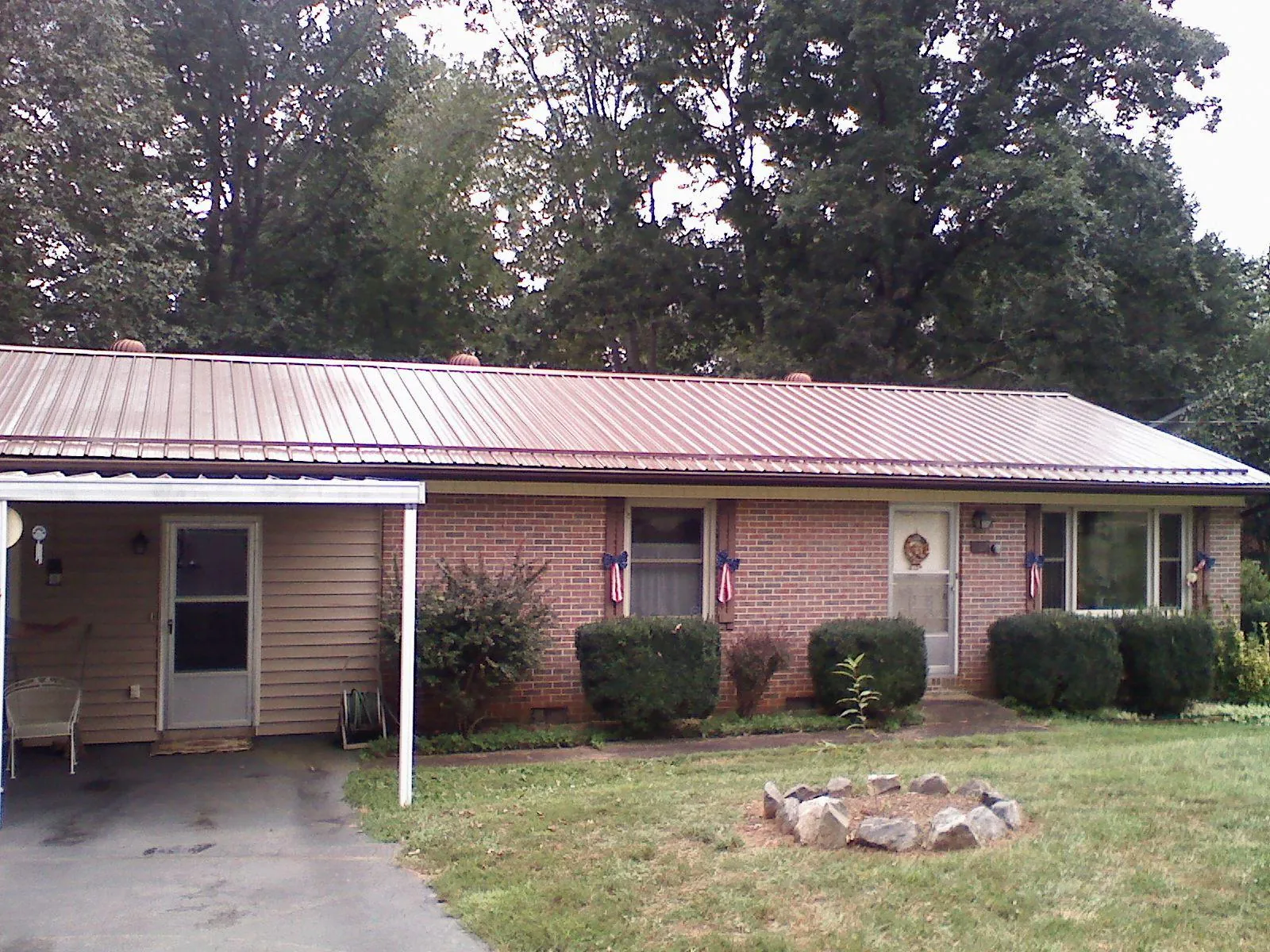 Bronze metal roof and carport on a brick ranch home — Roof Repair work by our crew in Rhinebeck